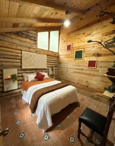 a bedroom with a bed in a log cabin at Cabaña Flor de Agave in Tres Marías