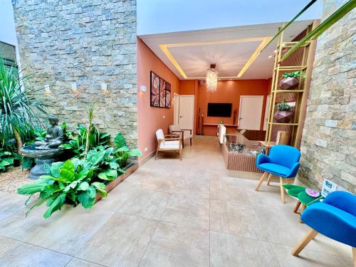 a lobby with a stone wall and blue chairs at Hotel Fazenda Vale Alvorada in Cascavel