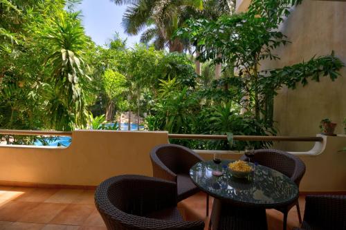 a patio with a table and chairs and trees at Palmar del Sol by Riviera Maya Suites in Playa del Carmen