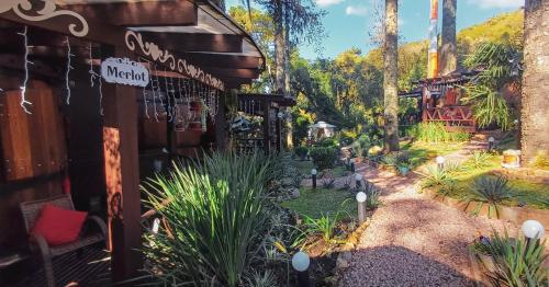 a garden outside of a building with plants at Chalé Temático em Pipa de Vinho - Parada da Pipa Chalés in Canela