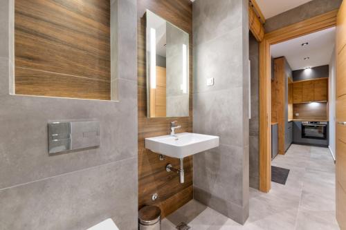 un baño con lavabo y espejo en Centar Gondola apartmani, en Zlatibor