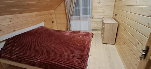 a room with a bed in a wooden room at Home comfort in Verkhovyna