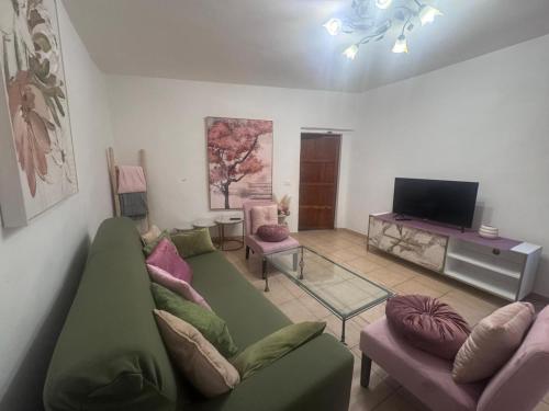 a living room with a green couch and a tv at Gabri's Home in Spello