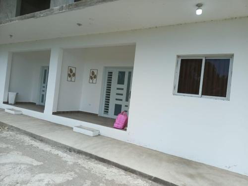 a white building with a little girl sitting in a window at Mi sueño Caribeño in Nagua