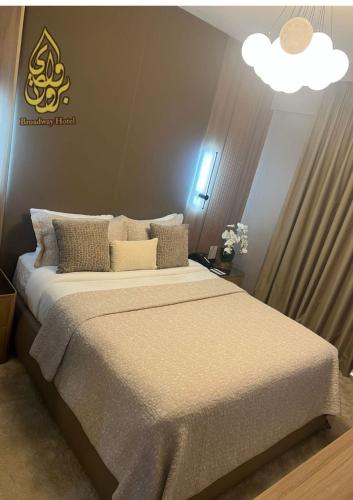 a bedroom with a large bed with a white blanket at Broadway Hotel in Dubai