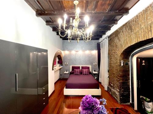 a bedroom with a bed and a chandelier at Domus31 - Luxury House in Trastevere in Rome