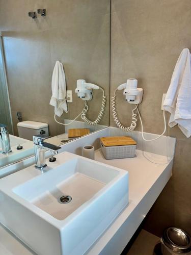 a bathroom with a white sink and a mirror at Ilhabela Flat in Ilhabela