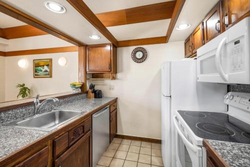a kitchen with a sink and a refrigerator at Kiahuna Plantation 323 in Kipu