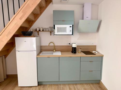 a kitchen with a white refrigerator and a microwave at Le Patio, 10 minutes from Béziers and 20 minutes from Pézenas in Pailhès