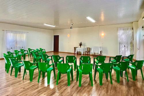 a large room with green chairs and a table at Hotel Fazenda Vale Alvorada in Cascavel