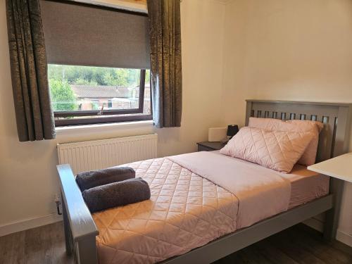 a small bedroom with a bed with a window at Cosy 3 Bedroom Bungalow with Private Parking and Rear Garden in Milton Keynes