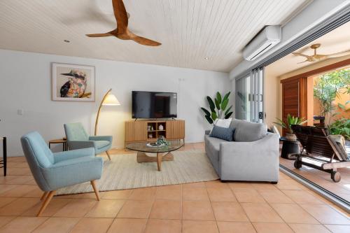 a living room with two chairs and a tv at L'Auberge @ Noosa in Noosa Heads