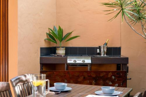 a kitchen with a table with a stove and a plant at L'Auberge @ Noosa in Noosa Heads