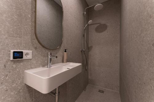 ein Badezimmer mit Waschbecken und Spiegel in der Unterkunft Affordable Private Room Near University Tilburg in Tilburg