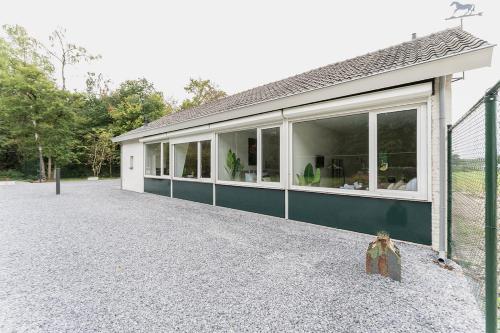 ein Haus mit großen Fenstern an der Seite in der Unterkunft Affordable Private Room Near University Tilburg in Tilburg