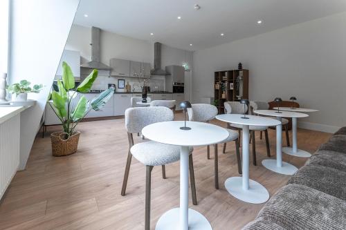 a living room with tables and chairs and a kitchen at Affordable Private Room Near University Tilburg in Tilburg