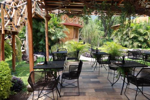 a patio with tables and chairs under a pergola at Villa Armonia Hotel & Spa in Jocotepec