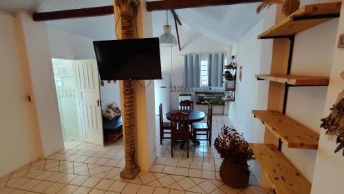 a living room with a table and a tv on a pole at Chalé Hilda in Holambra