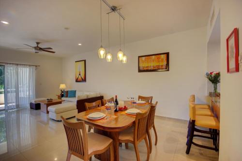 a dining room and living room with a table and chairs at Palmar del Sol by Riviera Maya Suites in Playa del Carmen