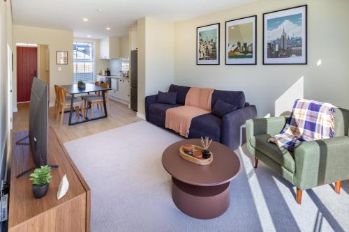 a living room with a couch and a table at Stylish 3BR Escape Parking & Modern Living in Christchurch