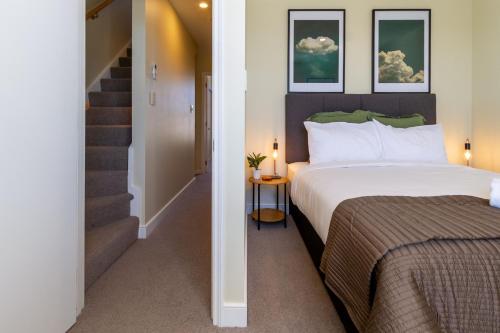 a hotel room with a bed and a staircase at Stylish 3BR Escape Parking & Modern Living in Christchurch