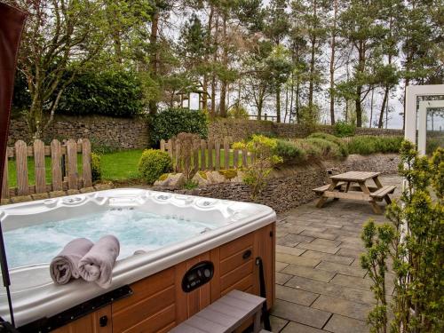 a jacuzzi tub in a backyard with a picnic table at 7 Bed in Tideswell 93808 in Tideswell