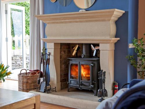 a fireplace in a living room with blue walls at 7 Bed in Tideswell 93808 in Tideswell