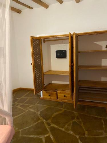a wooden cabinet with a tv in a room at Banana House in Watamu
