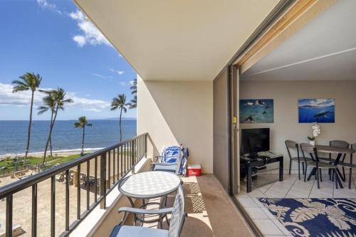 a balcony with a table and chairs and the ocean at SUGAR BEACH RESORT, #409 condo in Kihei