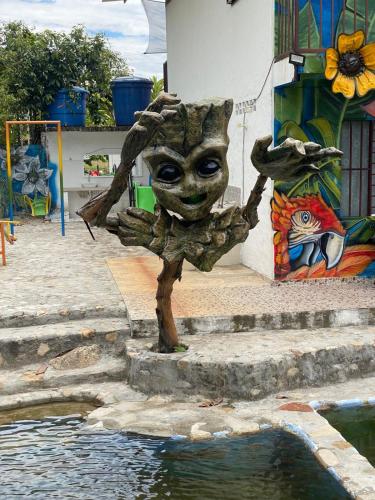 a statue of a baby groot next to a pool of water at Finca Turística Las Margaritas in Rivera