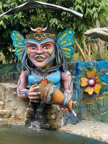 a statue of a woman holding a fish at Finca Turística Las Margaritas in Rivera