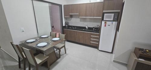 Conforto em Foz في فوز دو إيغواسو: مطبخ صغير مع طاولة وثلاجة
