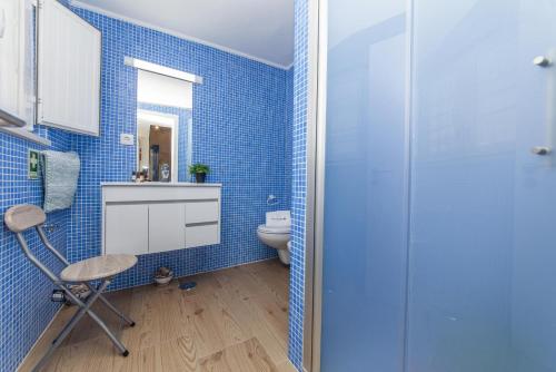 a blue bathroom with a toilet and a chair at B54 - Casa Azul in Burgau in Budens