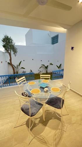 a dining room with a glass table and chairs at Sofia House sidi bou said in Sidi Bou Saïd