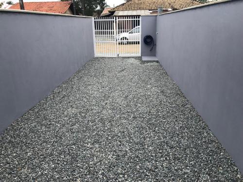 a fence with a gate and a driveway at Germinado familiar 5 in São Francisco do Sul