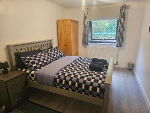 a bedroom with a bed and a window at Cosy 3 Bedroom Bungalow with Private Parking and Rear Garden in Milton Keynes