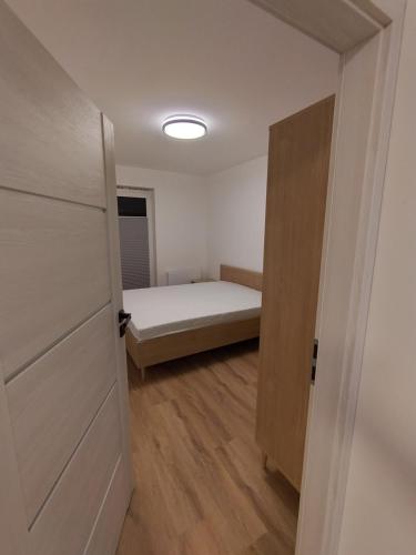 a small bedroom with a bed and a door at Podłęże Trawniki Industrial Zone 
