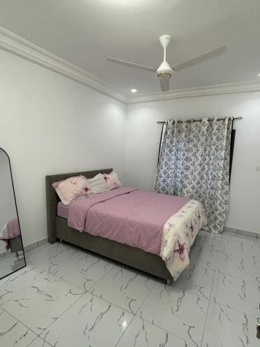 a bedroom with a bed and a ceiling fan at Kotu lux in Kotu