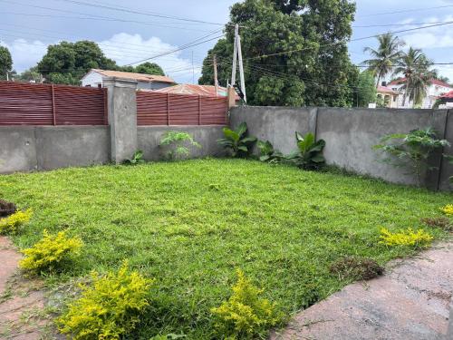 a yard with a fence and green grass at Kotu lux in Kotu