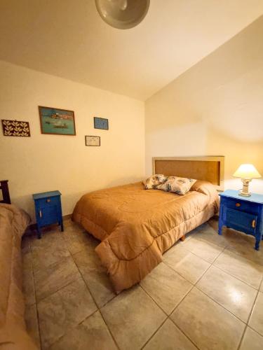 Un dormitorio con una cama y dos mesas azules. en Casa Ramona, en Embalse