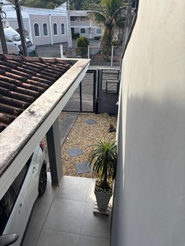a white car parked on a balcony with a plant at Casa Joinville in Joinville