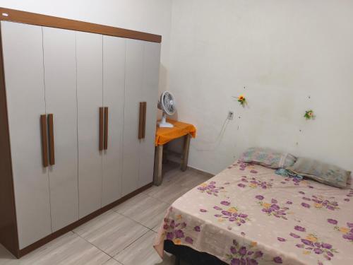 a bedroom with a bed and a dresser and a table at Casa Avance RH Aconchego in Camaçari
