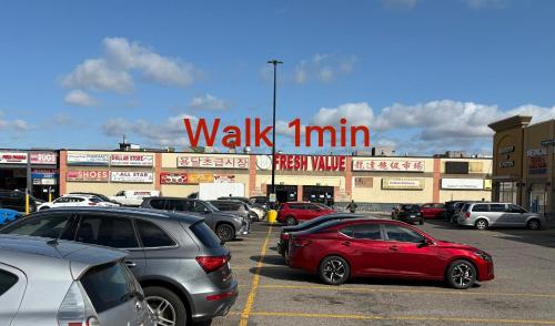 a parking lot with cars parked in front of a walkin sign at 9mins airport 1 min to shopping mall in Toronto