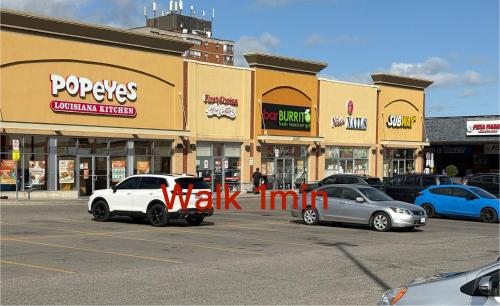 a parking lot with cars parked in front of buildings at 9mins airport 1 min to shopping mall in Toronto