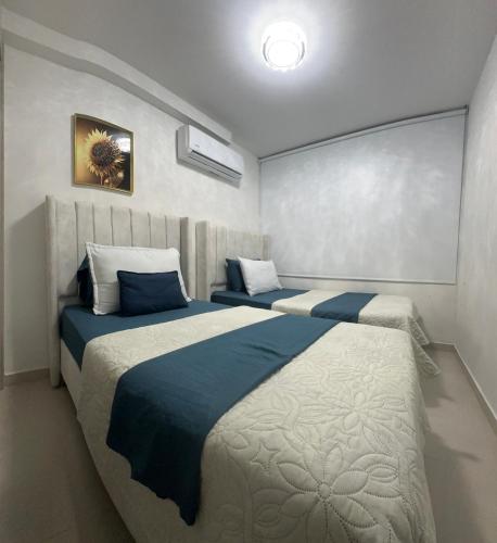 a bedroom with two beds with blue and white at Luxury norte Barranquilla in Barranquilla