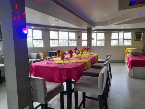 a dining room with a table with pink table cloth at Christar Villas Hotel in Kingston