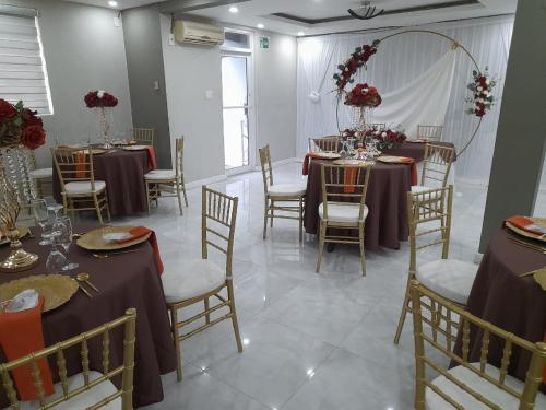 a room with tables and chairs with purple tablecloths at Christar Villas Hotel in Kingston