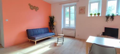 a living room with a blue couch and a television at La perle in Contrexéville