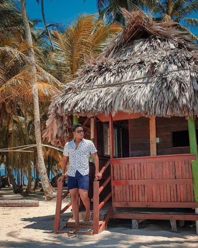 a woman standing in front of a small hut at Cabañas frente al mar Isla de Guna Yala Aroma in Niatupo