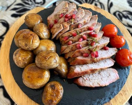 a plate of food with meat potatoes and vegetables at Pensiunea Bianca in Botoşani